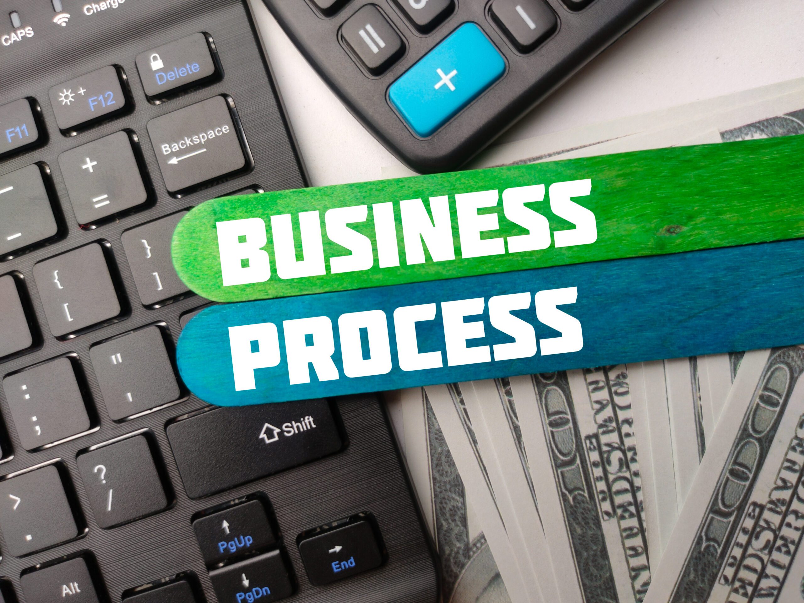 Keyboard,calculator and banknotes with the word BUSINESS PROCESS